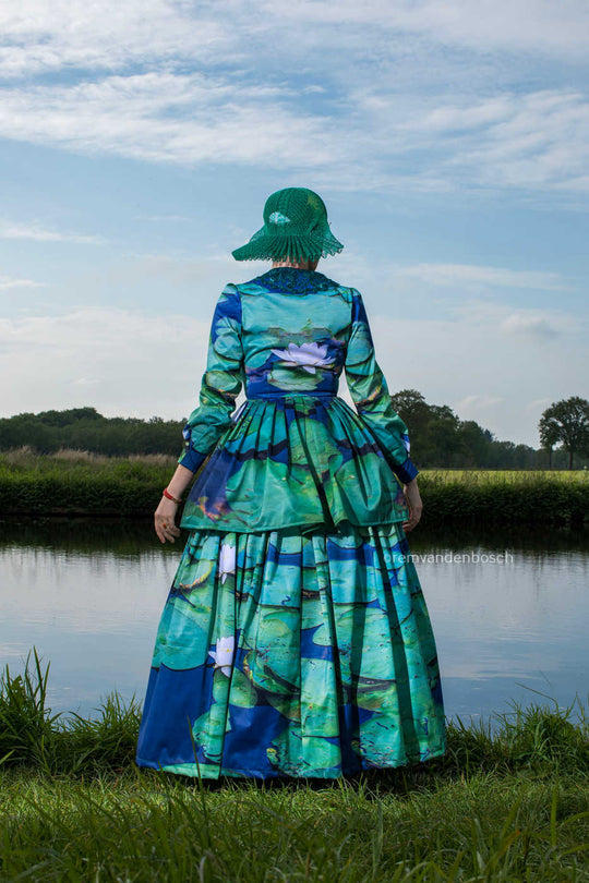 Achteraanzicht van Linde in moderne groene Friese dracht met waterlelieprint aan het water. Fotografie Rem van den Bosch 