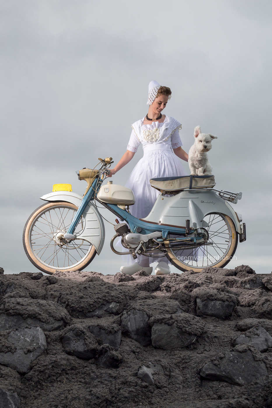 Staand fotobeeld van Yael in spierwitte moderne Walcherse dracht met brommer en wit hondje, Zeeuwse wandkunst