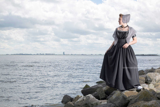 Liggend fotobeeld van Rebecca in moderne grijze Walcherse dracht, Zeeuwse wandkunst