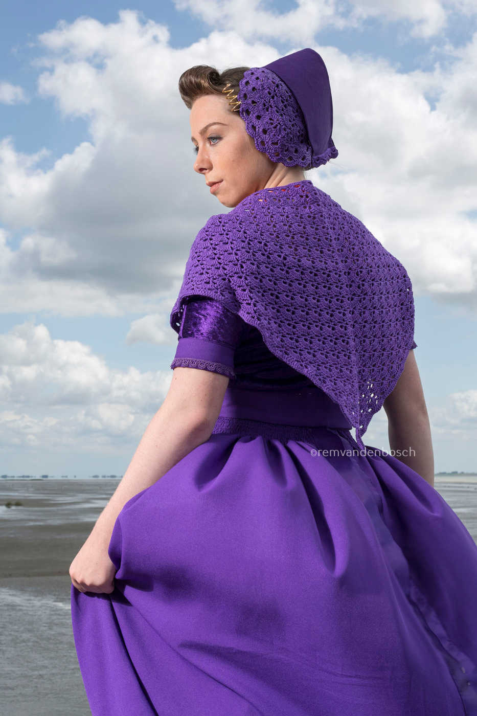 Loeki in moderne paarse Walcherse dracht in zijaanzicht met zicht op de achterkant, ingetogen Zeeuwse wandkunst