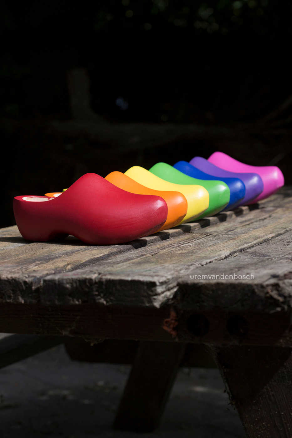 Staand fotobeeld van zeven gekleurde klompen in regenboogkleuren , Zeeuws Meisje, gefotografeerd door Rem van den Bosch 
