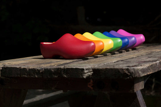 Liggend fotobeeld van zeven gekleurde klompen in alle kleuren van de regenboog, Zeeuws Meisje. Gefotografeerd door Rem van den Bosch 