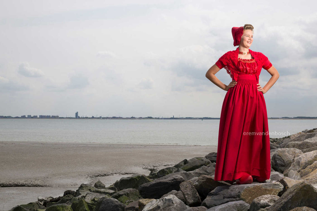 Liggend fotobeeld van Phoebe in moderne rode Walcherse dracht, trotse Zeeuwse wandkunst