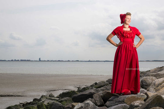 Liggend fotobeeld van Phoebe in moderne rode Walcherse dracht, trotse Zeeuwse wandkunst