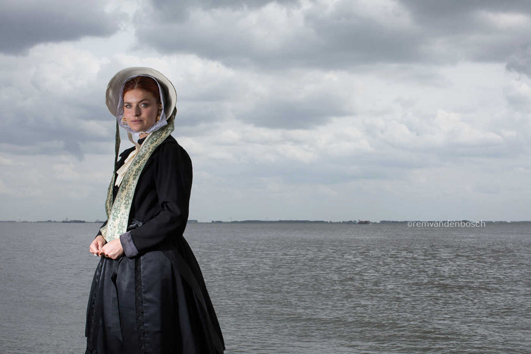 Liggend portret van Charlotte in zondagse dracht met zee, kunstfotografie door Rem van den Bosch