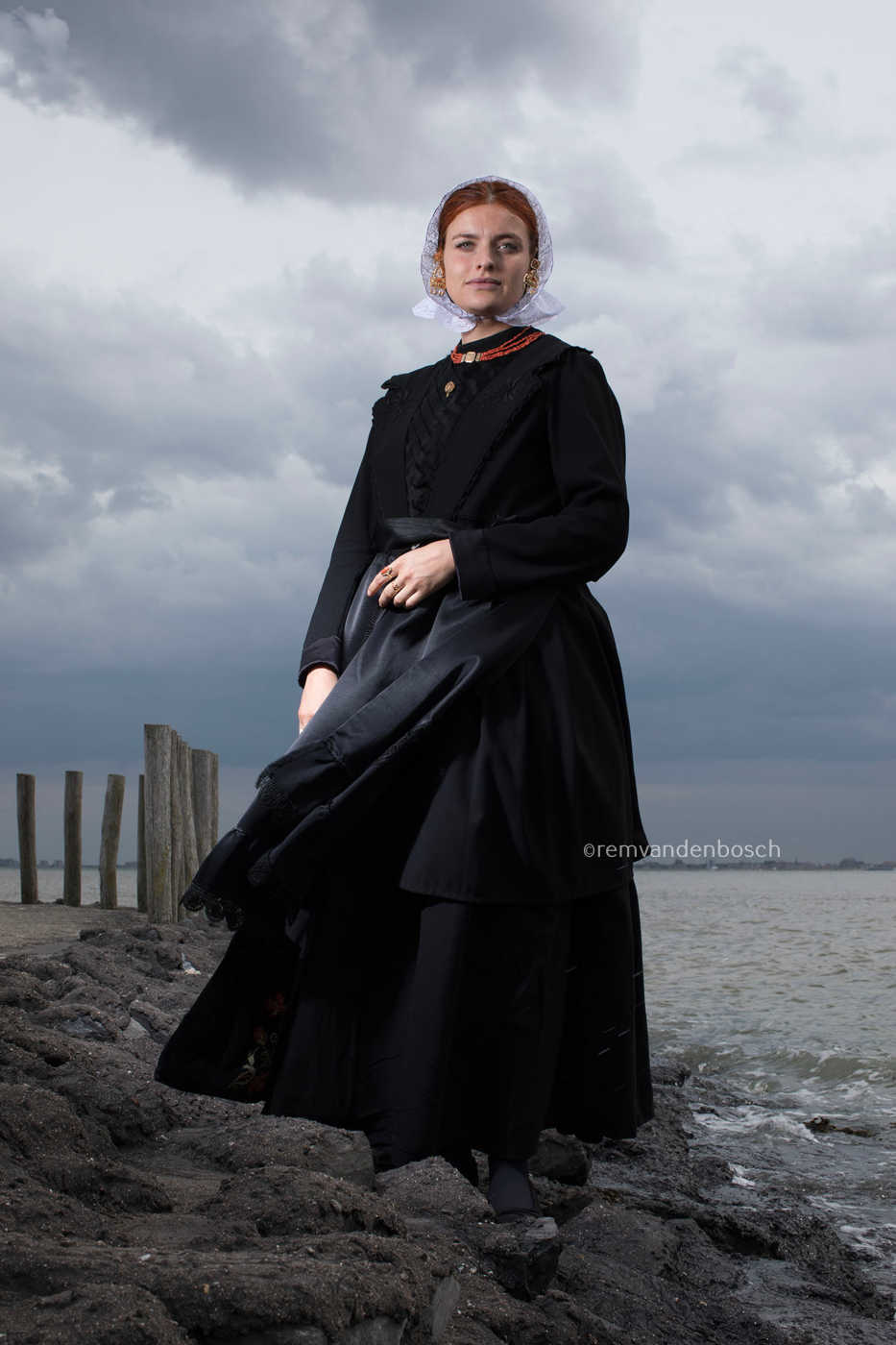 Staand portret van Charlotte in Cadzandse dracht met wind, kunstfotografie door Rem van den Bosch