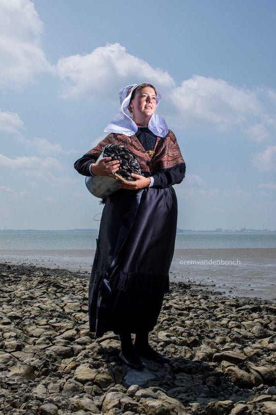 Hanna in traditionele Hulster dracht met een emmer mosselen – kunstfotografie door Rem van den Bosch