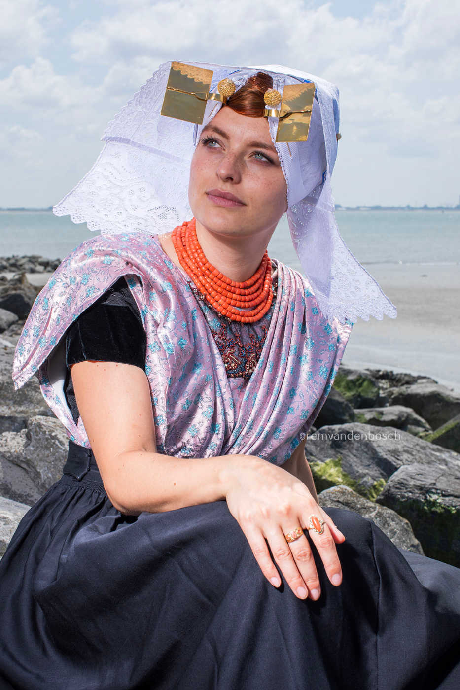 Charlotte zittend op de dijk in Zuid Bevelandse dracht 