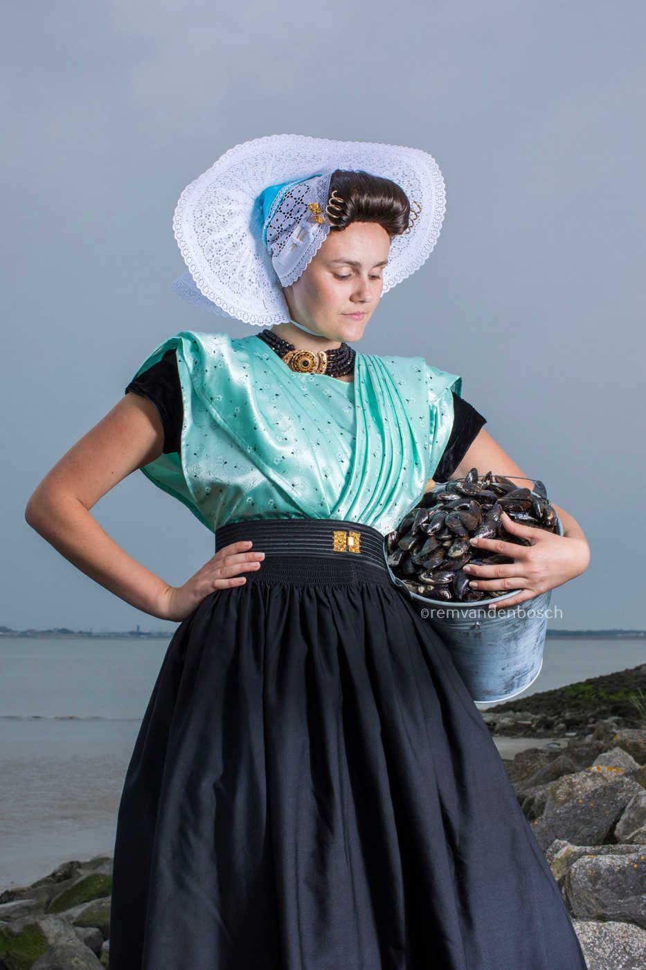 Linde in traditionele Arnemuidse dracht met een emmer mosselen – kunstfotografie door Rem van den Bosch
