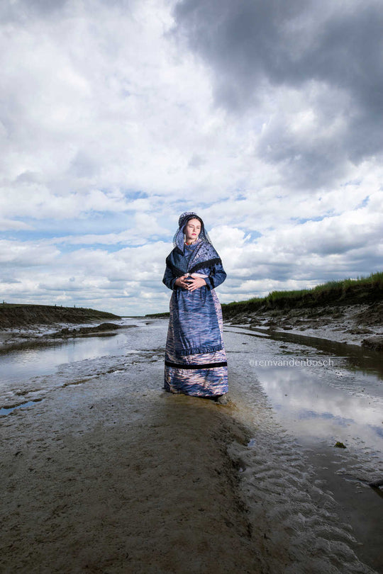 Lois in moderne Hulster dracht in blauw-grijze tinten in Saeftinghe, kunstfotografie door Rem van den Bosch