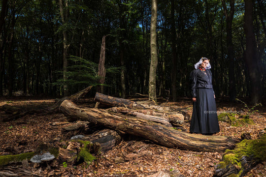 Liggend portret van Linde in de dracht van Gooi en Eemland op een open plek in het bos. Fotografie Rem van den Bosch 