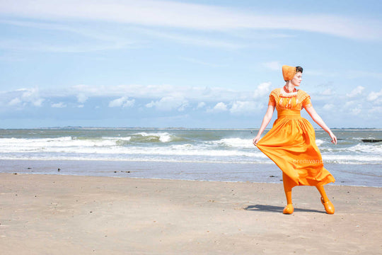 Liggend beeld Linde in oranje moderne dracht aan zee, Rem van den Bosch 