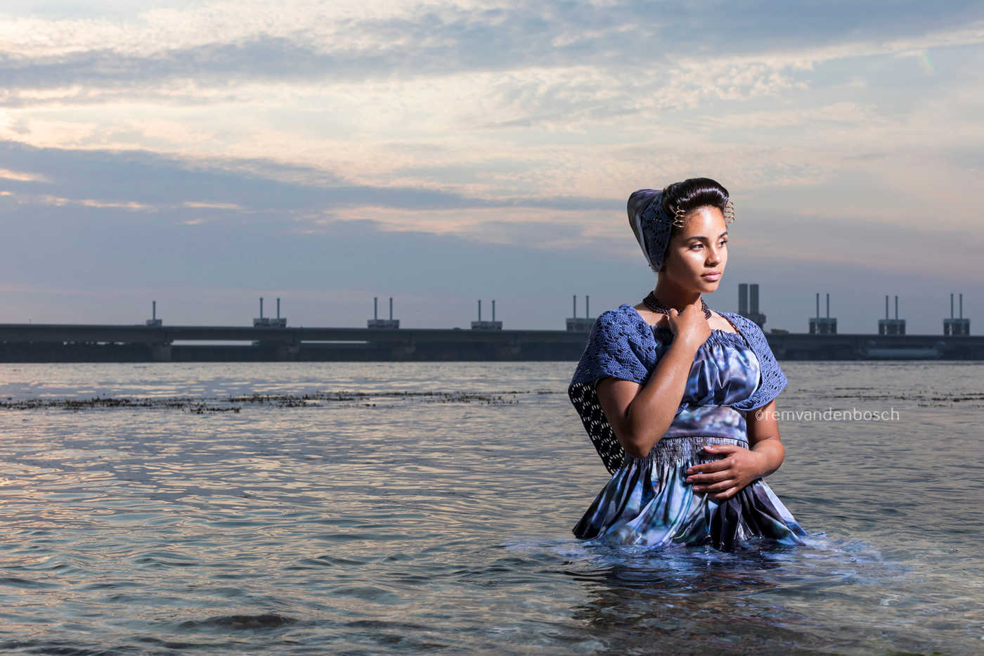 Liggend fotobeeld van Narena in moderne Walcherse dracht met oesterprint bij de stormvloedkering