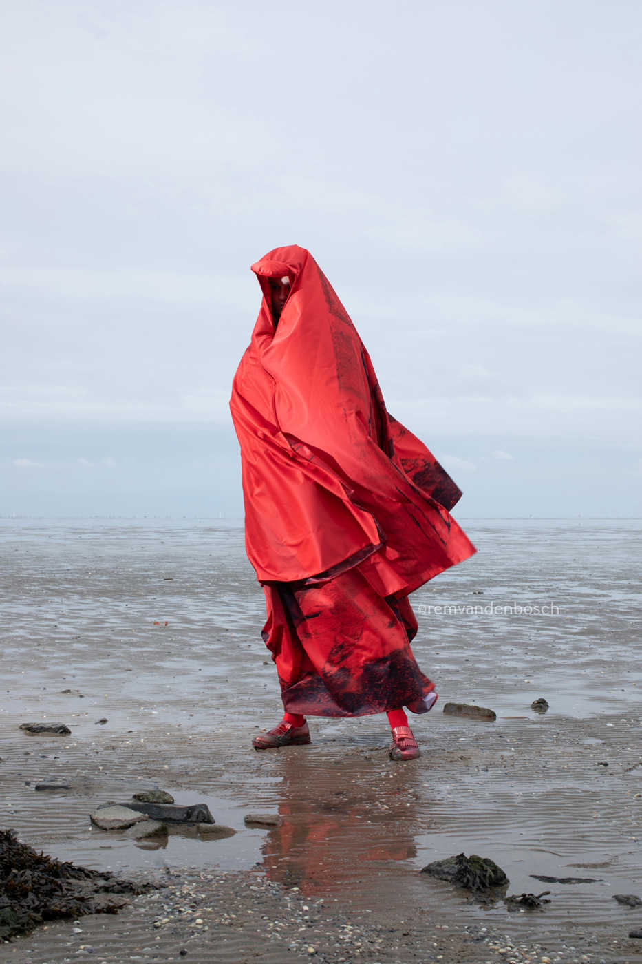 Linde in moderne rode rouwdracht van Wieringen met rouwcape, staand in het wad , Nederlandse wandkunst, fotografie Rem van den Bosch 