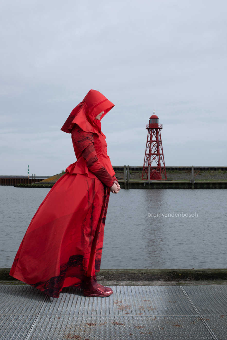 Linde in rode rouwdracht van Wieringen aan de haven met vuurtoren op de achtergrond , Nederlandse wandkunst door Remvan den Bosch