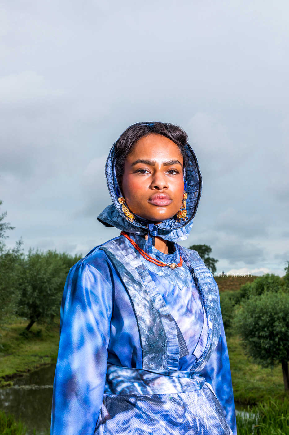 Portret van Jazzmine in moderne Cadzandse dracht in blauwtinten met traditionele sieraden – kunstfotografie door Rem van den Bosch