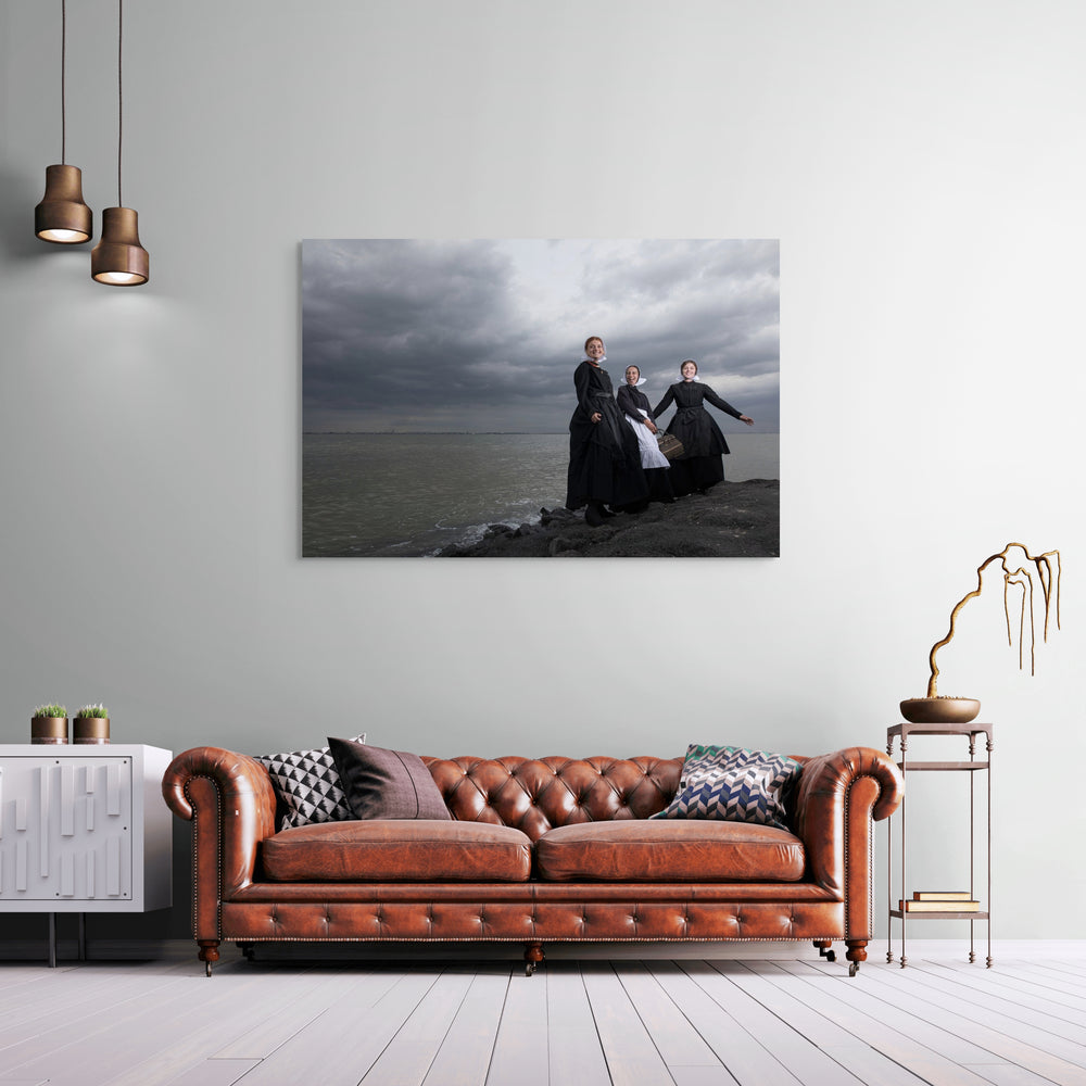 Liggend portret van Charlotte, Janis en Ilyana in Cadzandse dracht aan zee, stralend en vrolijk, kunstfotografie door Rem van den Bosch, muurdecor, wall art 