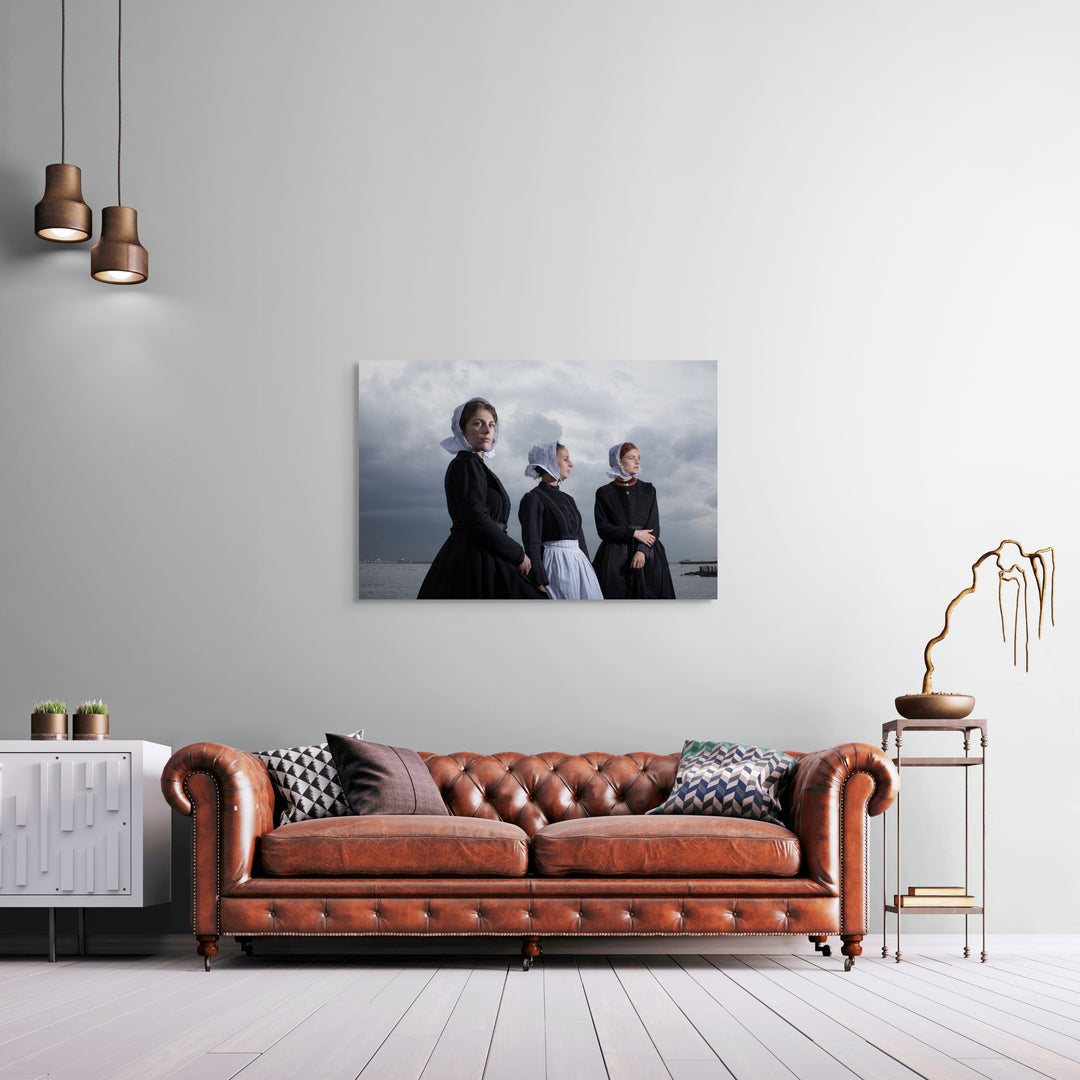 Liggend groepsportret van Charlotte, Janis en Ilyana in Cadzandse dracht aan zee, kunstfotografie door Rem van den Bosch, muurdecoratie, fotografie 