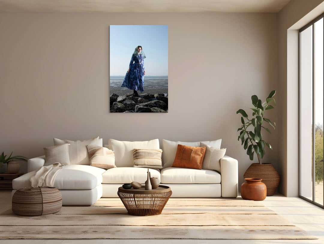 mock up Portret van Linde in de moderne blauwe Thoolse dracht aan zee op de rotsen. Verkrijgbaar op dibond of plexiglas via Zeeuwsmeisje.nu