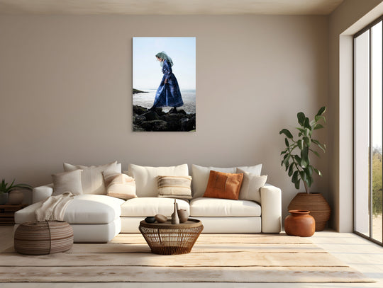 Portret van Linde in de moderne Thoolse dracht aan zee terwijl zij loopt over rotsen. 